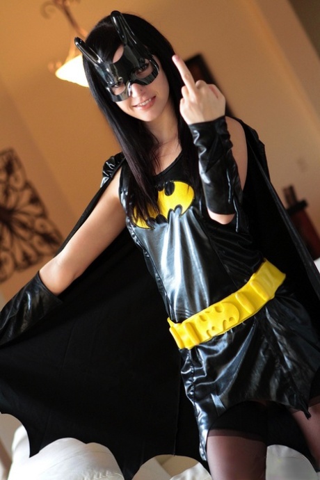 Dark haired chick Catie Minx takes off a Batman suit to model in the nude