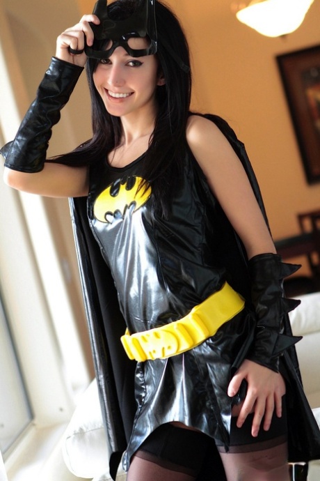 Dark haired chick Catie Minx takes off a Batman suit to model in the nude