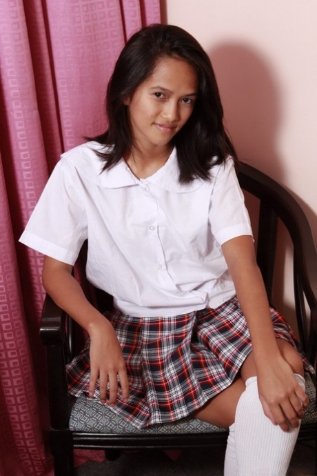 Asian schoolgirl works a massive dildo into her virgin pussy in white socks