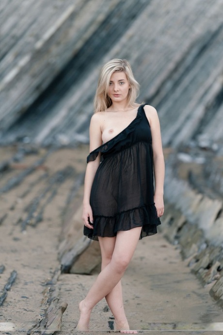 Young blonde Anna T removes black lingerie for a nude shoot at low tide