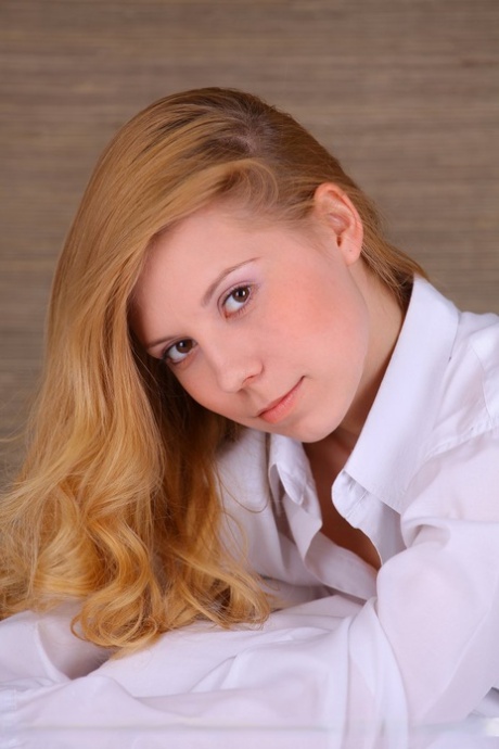 Pale redhead Stella D casts sultry looks during a nude shoot on her bed