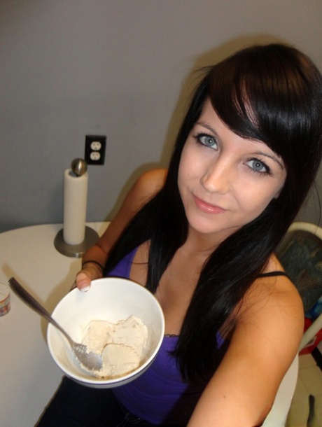 Dark haired teen Andi Land covers her tits and ass in food products