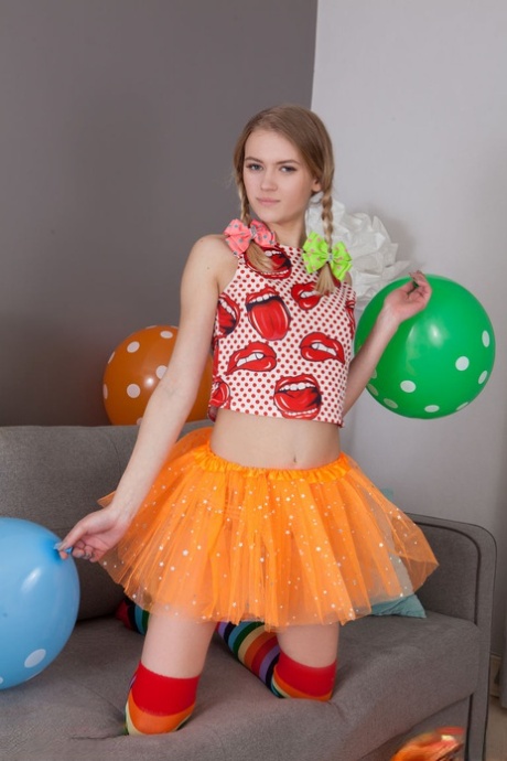 Skinny teen Lili removes her clothes and long socks to pose nude amid balloons