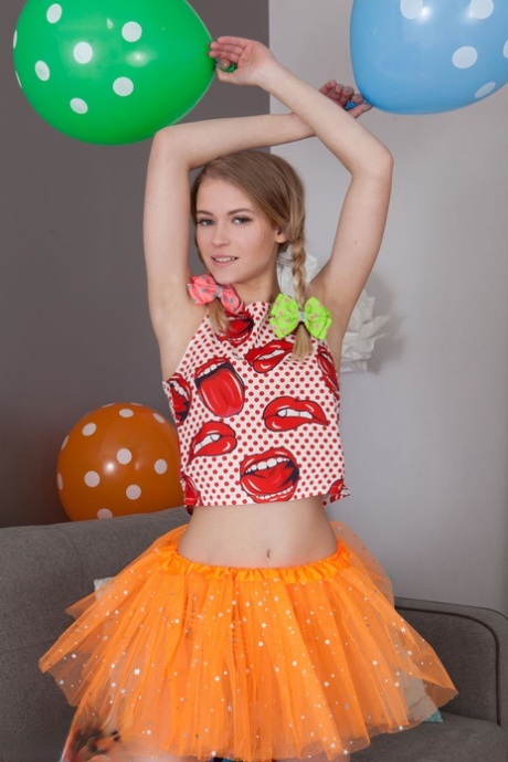 Skinny teen Lili removes her clothes and long socks to pose nude amid balloons