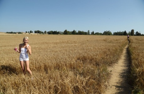 Thin blonde teen Kiara Cole fist fucks her pussy out in a farmer's field