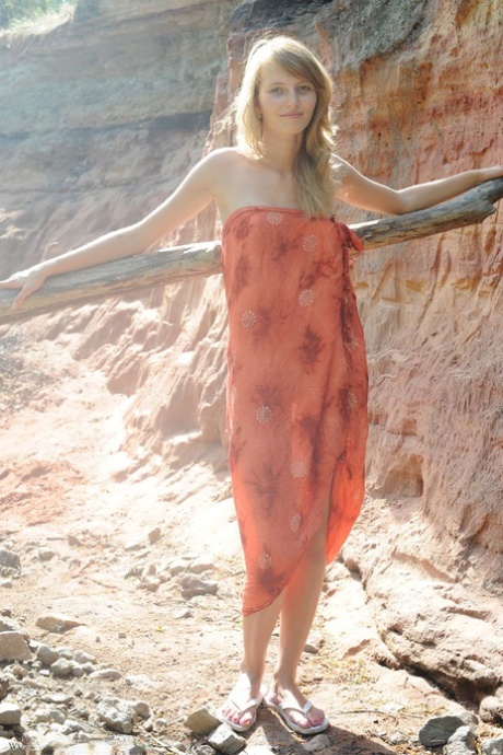 Slim teen Eriska A exposes her tan lined body while wandering a canyon