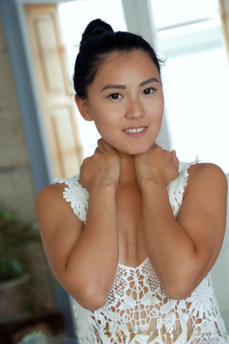 Young Asian girl Kimiko wears her hair up while showcasing her naked pussy
