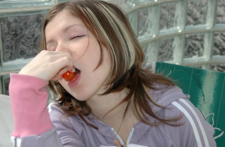 Barely legal girl sucks on cherry tomatoes while showing her upskirt underwear