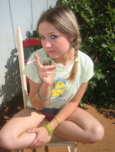 Young girl smokes a cigarette while exposing her tits and pussy