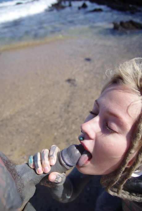 Tattooed girl jerks and sucks a tattooed penis near the ocean