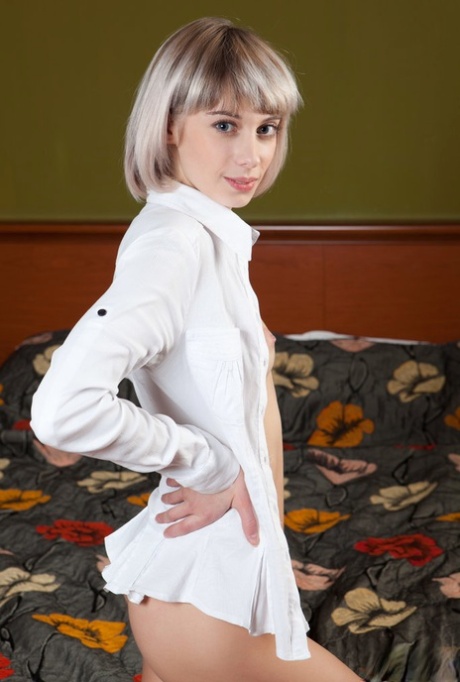 Young blonde Queva poses nude on a bed with her shirt unbuttoned