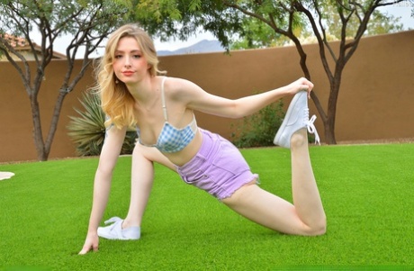 Skinny blonde Hailee displays her flexibility before masturbating in a yard