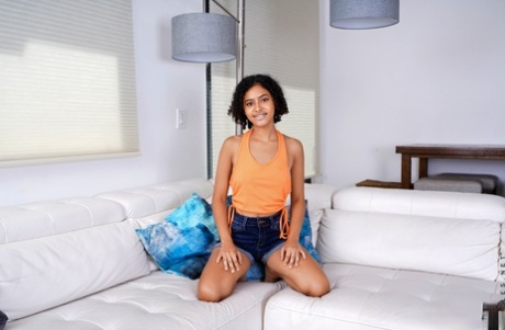 Nice teen Dani Diaz sets her tan lined figure free of clothing on a sofa