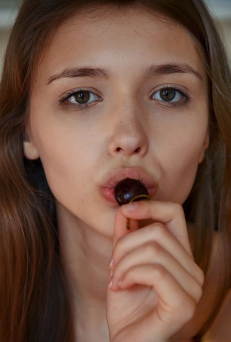 Young beauty Mila snacks on a plate of cherries while getting naked