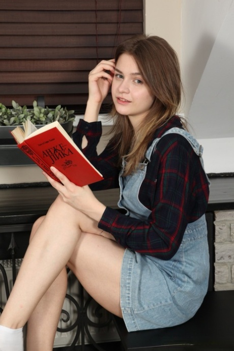 Nice teen Minni Love reads a hardcover book before getting totally naked