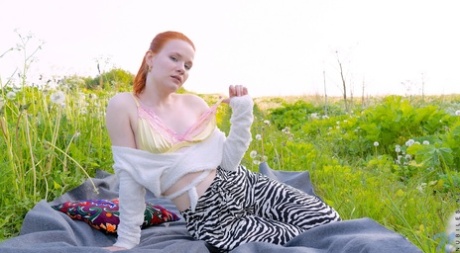 Pale redhead Fox Eva masturbates with a vibrator on a blanket in the outdoors