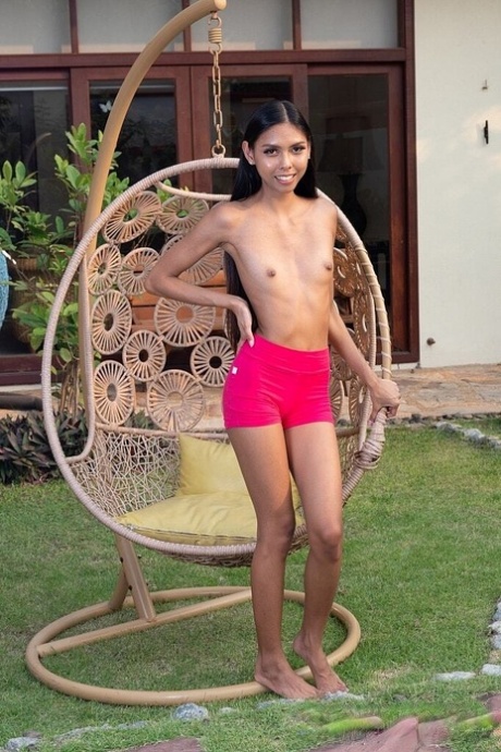 Skinny brunette teen gets totally naked in a backyard setting