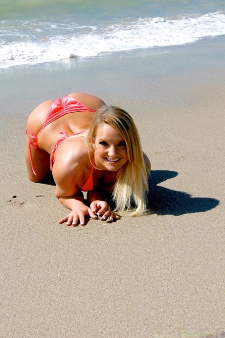 Sexy blonde with tattoos doffs bikini bra to feel the breeze on natural tits