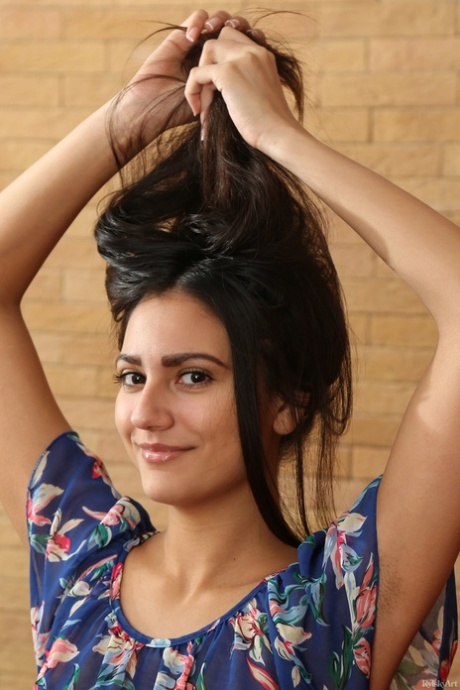 Dark haired girl Cira Nerri stares out with beautiful eyes while getting naked