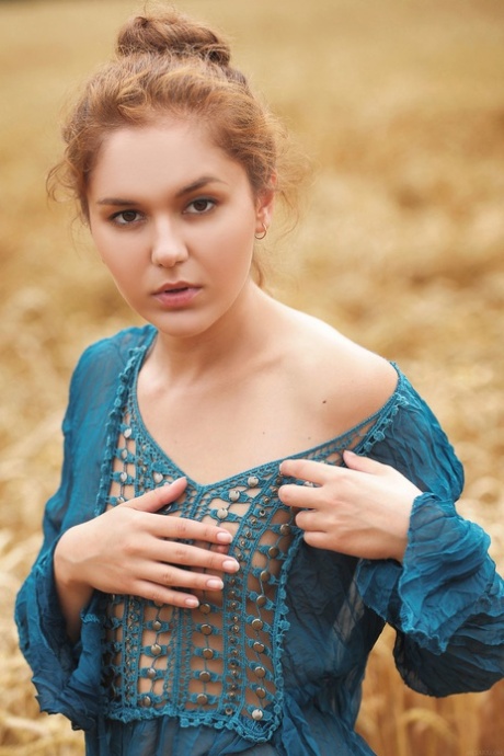 Ginger teen Jenya A strips off her lovely dress and poses naked in the filed