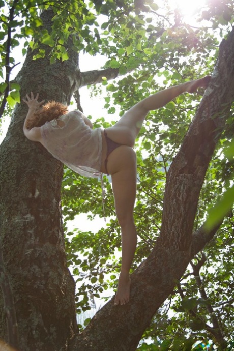 Fit babe Avina flaunts her big ass & pink pussy in a wild striptease in a tree