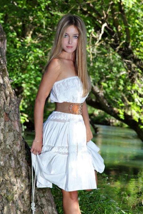 Skinny teen model Elise A losing her dress and posing nude in nature