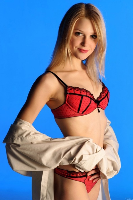 Blonde teen Tanya J removes her red underwear and poses naked in a solo