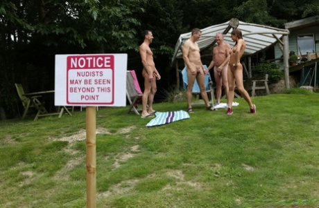 Lovely clothed female students blow off a nudist colony outdoors