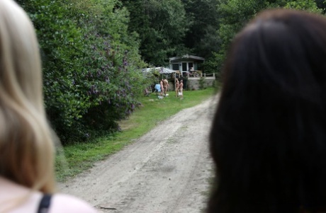 Lovely clothed female students blow off a nudist colony outdoors
