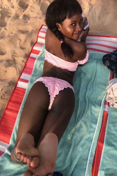 Petite ebony Noemie Bilas exposing her tits pussy and feet in a solo