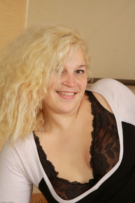 Chubby hottie Tina Christina strips on the bed and massages her hairy pussy