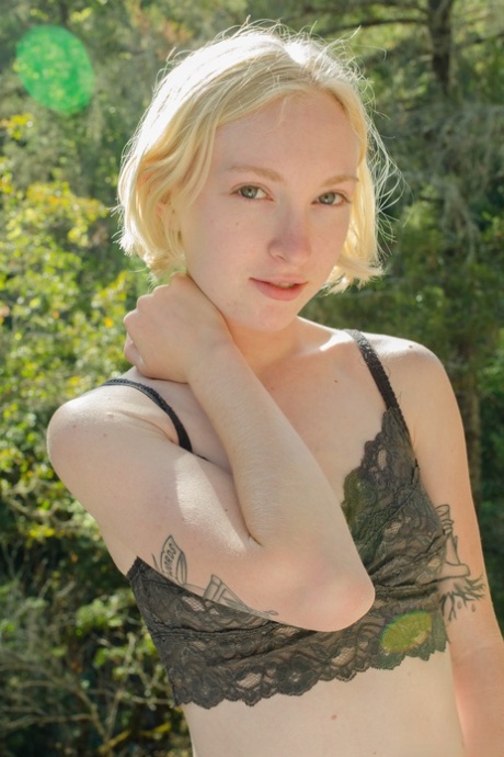 Slender blonde amateur Ivy Blair shows her tattoos and hairy pussy outdoors