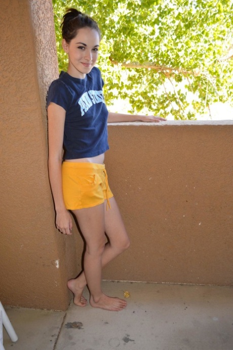 Skinny teen Emily Grey strips her sexy yellow shorts & shows her round booty
