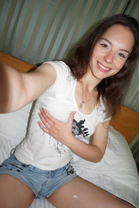 Brunette honey exposes her small tits and takes selfies in the mirror
