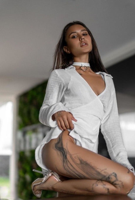 Alluring babe Camilla shows off her tattooed naked body in a hot striptease