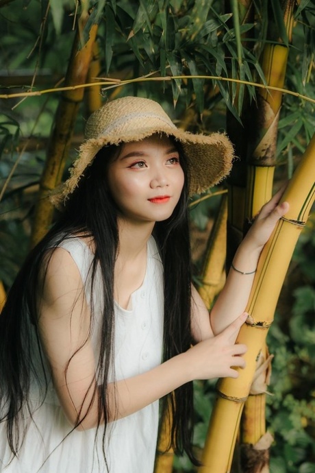 Great looking Asian girl posing in her white dress in beautiful nature