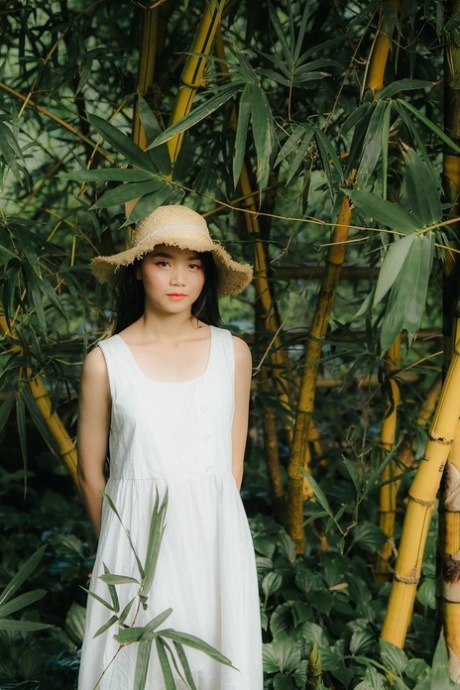 Great looking Asian girl posing in her white dress in beautiful nature