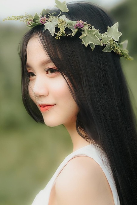 Great looking Asian girl posing in her white dress in beautiful nature