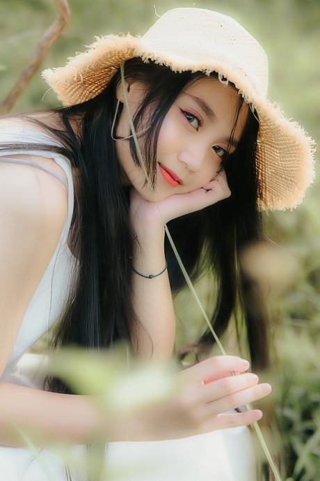Great looking Asian girl posing in her white dress in beautiful nature